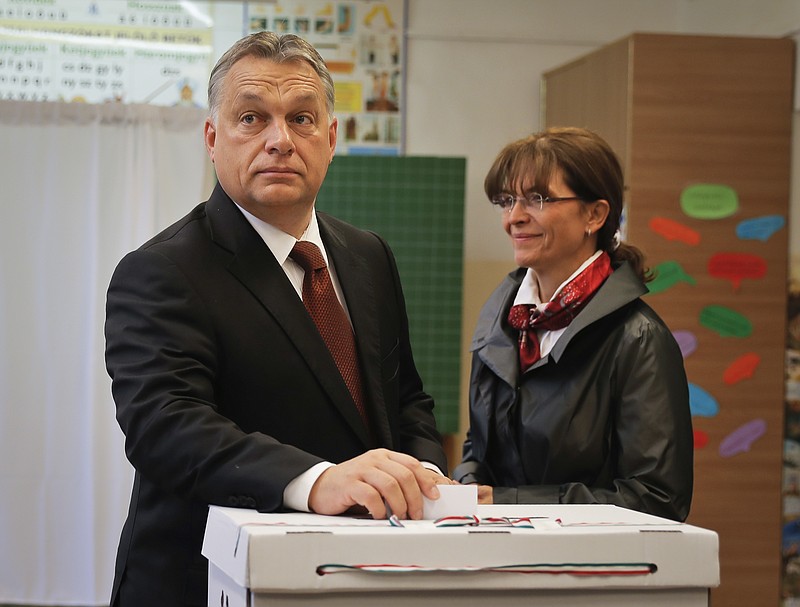 
              Hungarian Prime Minister Viktor Orban casts his vote in the referendum as his wife Aniko Levai stands by in Budapest, Hungary, Sunday, Oct. 2, 2016. Hungarians vote in a referendum which Prime Minister Viktor Orban hopes will give his government the popular support it seeks to oppose any future plans by the European Union to resettle asylum seekers among its member states. (AP Photo/Vadim Ghirda)
            