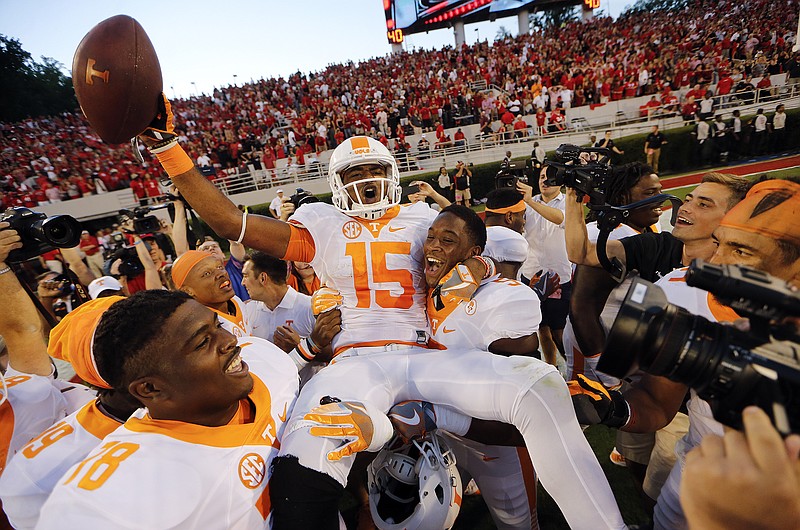 Tennessee wide receiver Jauan Jennings is carried by teammates Kyle Phillips, right, and Charles Mosley, left, after making a last-second touchdown catch in Saturday's 34-31 win at Georgia.