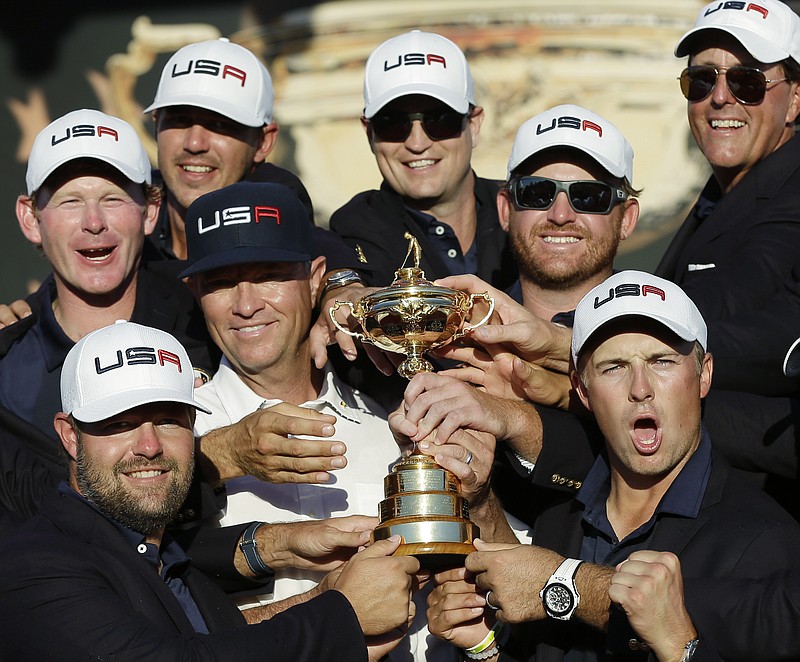 United States captain Davis Love III is surrounded by his players as they pose for a picture during the closing ceremony of the Ryder Cup golf tournament Sunday, Oct. 2, 2016, at Hazeltine National Golf Club in Chaska, Minn. (AP Photo/David J. Phillip)