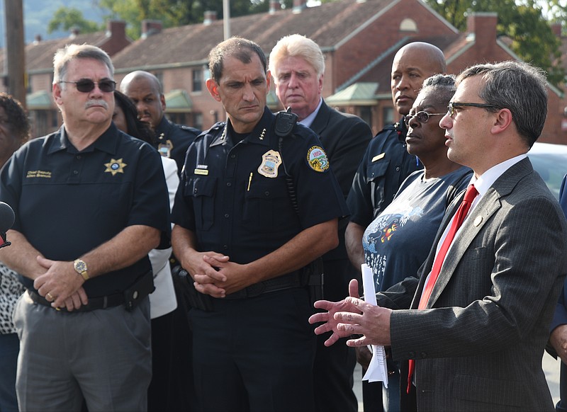 District Attorney Neal Pinkston, right, speaks during a press conference to announce the filing of a petition to abate certain gangs as a nuisance and to create an East Lake Safety Zone.