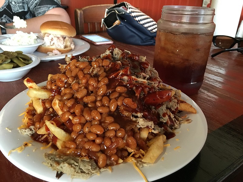 The barbecue fry plate at Hillbilly Willy's is a bed of fries topped with the house sauce, cheese, choice of meat, a side of slaw and barbecue beans. Sweet tea is served in a jelly jar.