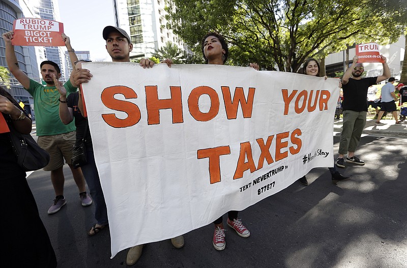 Protestors march in a downtown Miami street last month holding a sign in support of Republican presidential candidate Donald Trump releasing his tax returns. (AP Photo/Lynne Sladky)