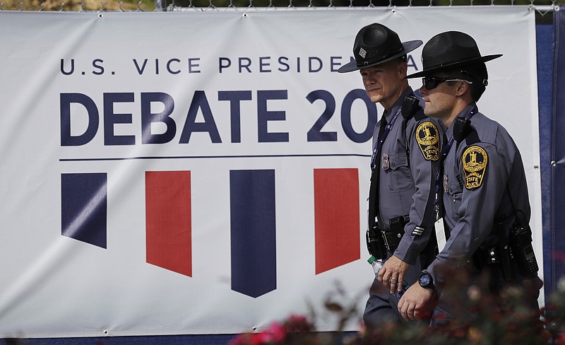 Police officers walk outside a security fence around Longwood University before the vice-presidential debate between Republican vice-presidential nominee Gov. Mike Pence and Democratic vice-presidential nominee Sen. Tim Kaine in Farmville, Va., Tuesday, Oct. 4, 2016.