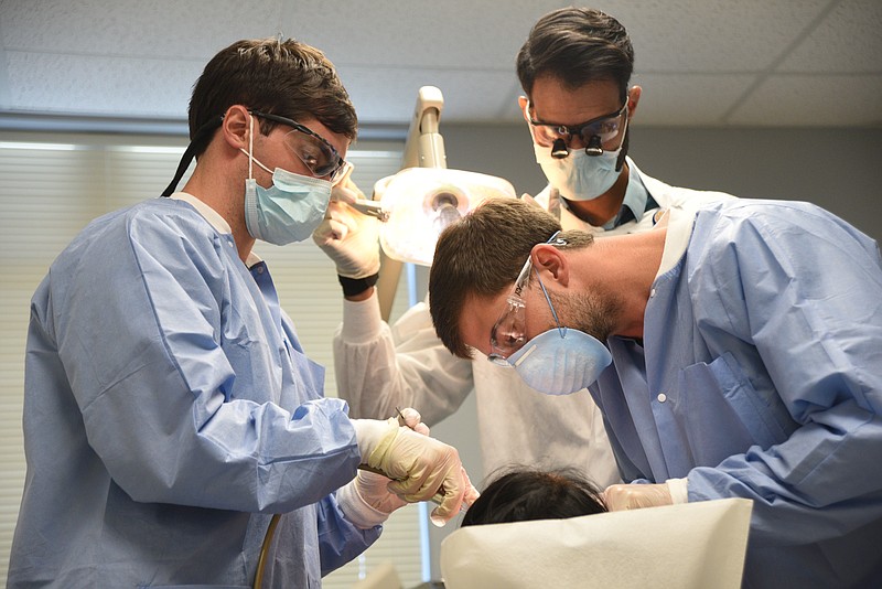 Student dentists Cale Atteberry, left, and Michael Fesmire, right, work as dentist Srikar Vulugundam watches Friday, Sept. 30, 2016 at the Dodson Avenue Community Health Center.