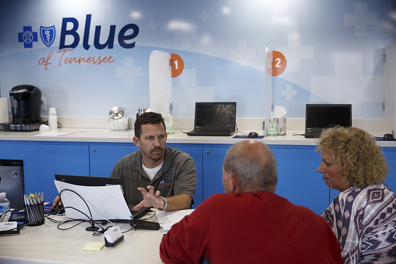 James Marx, left, helps Jeff Leskosek, center, and Sheri Leskosek sign up for health insurance in a mobile BlueCross BlueShield bus at the Northgate Mall parking lot Friday, Dec. 11, 2015, in Chattanooga, Tenn. Tuesday marks the deadline to sign up for insurance coverage which would begin on Jan. 1st.