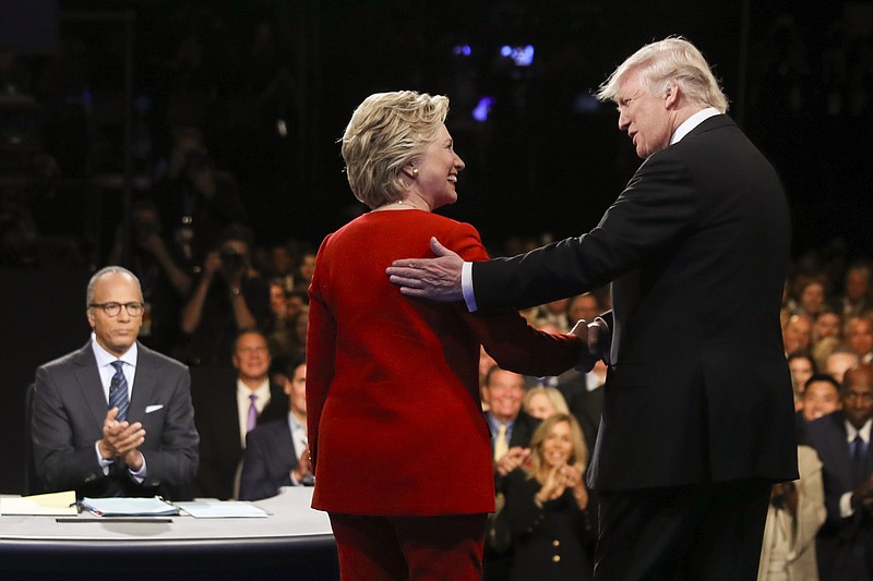  In this Sept. 26, 2016 file photo, Democratic presidential nominee Hillary Clinton and Republican presidential nominee Donald Trump shake hands during the presidential debate at Hofstra University in Hempstead, N.Y. For presidential candidates, the town hall debate is a test of stagecraft as much as substance. When Hillary Clinton and Donald Trump meet in the Sunday, Oct.9, 2016, contest, they'll be fielding questions from undecided voters seated nearby. In an added dose of unpredictability, the format allows the candidates to move around the stage, putting them in unusually close proximity to each other. (Joe Raedle/Pool via AP, File)