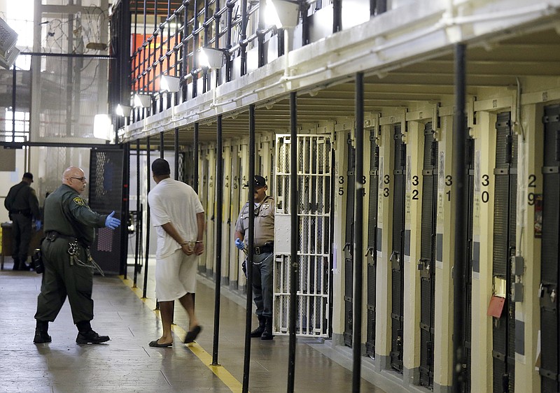 
              In this Aug. 16, 2016 photo, a condemned inmate is led out of his east block cell on death row at San Quentin State Prison in San Quentin, Calif. Proposition 66, which would shorten the appeals time in death penalty cases to five years, is supported by prosecutors and law enforcement who say it will begin to clear the legal bottleneck blocking the path to the death chamber. Attorney Barry Scheck, founder of the Innocence Project, cited several cases in which condemned prisoners had been found innocent, in some cases decades after their conviction, and one after he had been executed in Texas. (AP Photo/Eric Risberg, File)
            