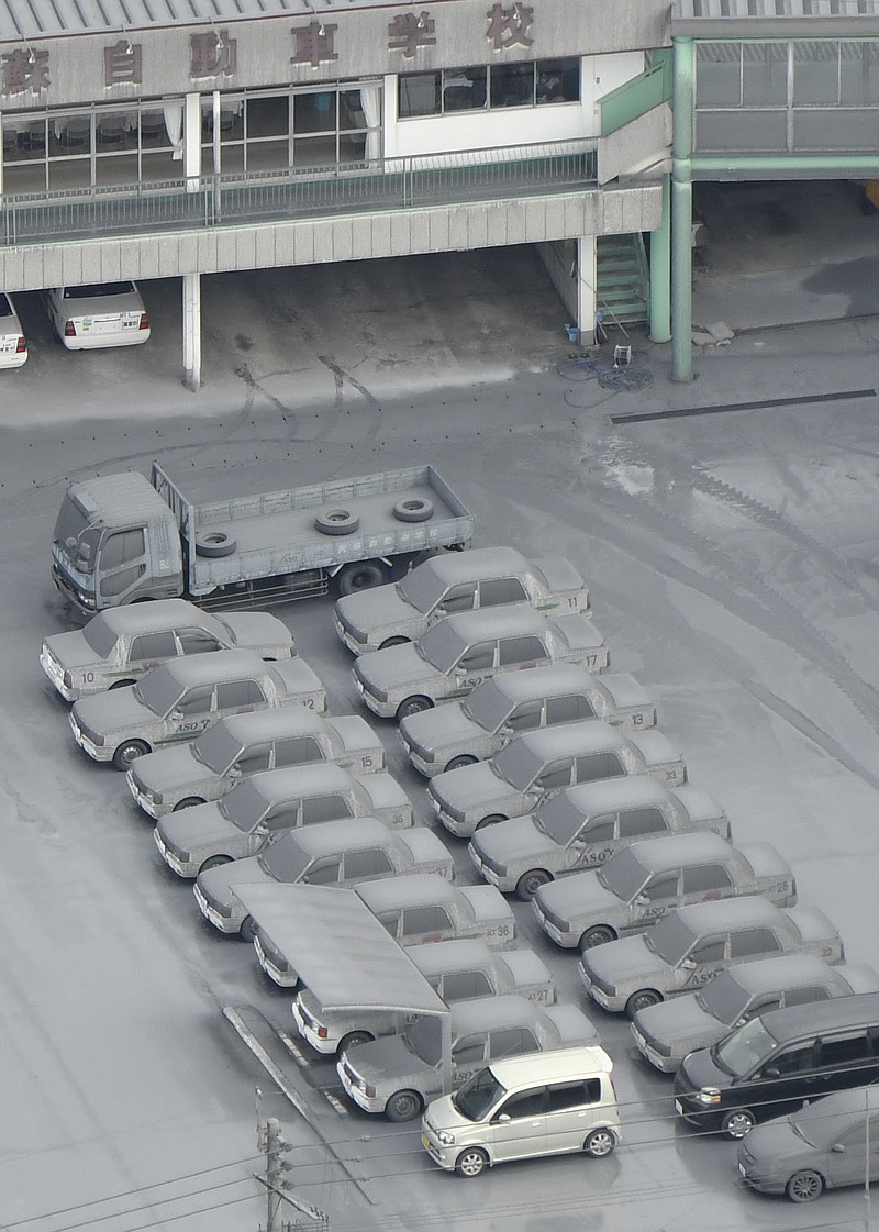 
              This aerial photo shows cars totally covered by gray ash parked on the compound of a driving school in Aso, Kumamoto Prefecture, southern Japan, Saturday morning, Oct. 8, 2016, following Mount Aso erupted earlier in the day. Mount Aso has sent huge plumes of gray smoke as high as 11 kilometers (6.8 miles) into the air in one of the volcano's biggest explosions in years. (Hiroko Harima/Kyodo News via AP)
            