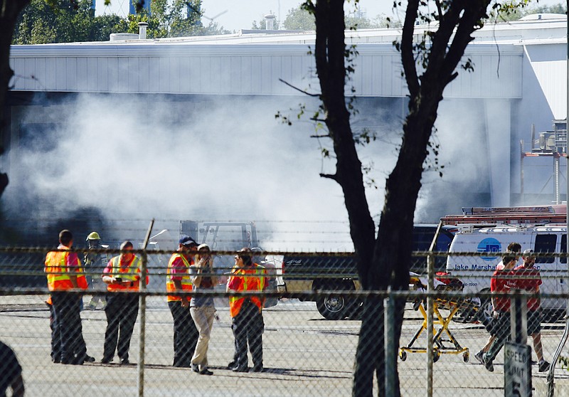 Emergency workers gather near the scene of a chemical explosion at the Amnicola Highway Coca Cola facility on Friday.