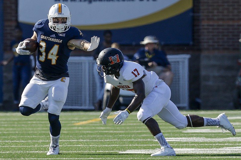 UTC running back Derrick Craine stiff-arms Mercer defensive back Eric Jackson during the Mocs' home football game against the Mercer Bears at Finley Stadium on Saturday, Oct. 8, 2016, in Chattanooga, Tenn.