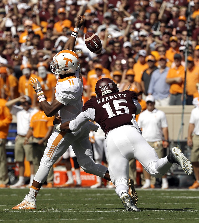 Tennessee quarterback Joshua Dobbs (11) loses the ball as he is hit by Texas A&M defensive lineman Myles Garrett (15) during the first half of an NCAA college football game Saturday, Oct. 8, 2016, in College Station, Texas. Texas A&M recovered the fumble. (AP Photo/David J. Phillip)