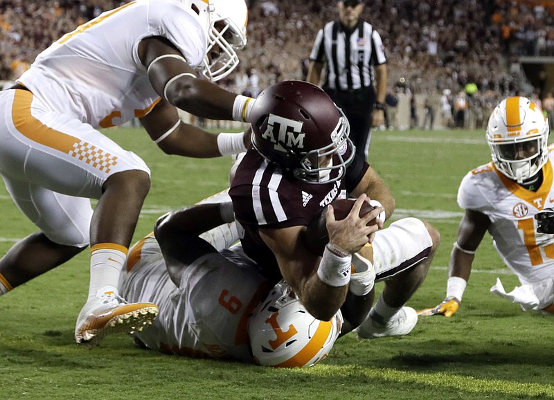 Texas A&M quarterback Trevor Knight dives over Tennessee defensive end Derek Barnett to score what proved to be the game-winning touchdown during overtime of Saturday's Southeastern Conference matchup between top-10 teams in College Station, Texas.
