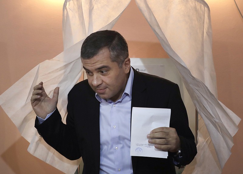 
              David Bakradze, leader of Georgia's largest opposition party United National Movement, leaves a voting booth with his ballot at a polling station in Tbilisi, Georgia, Saturday, Oct. 8, 2016. An undercurrent of political violence is unsettling voters in Georgia as they elect members of parliament on Saturday from a field that includes candidates from the country’s two main parties and a bewildering array of nearly two dozen other contenders. (AP Photo/Sergei Grits)
            