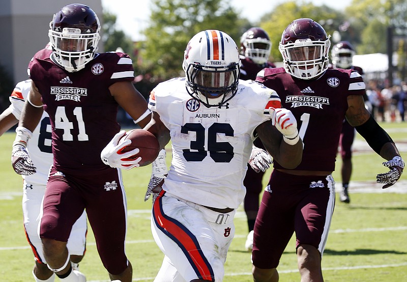 Auburn running back Kamryn Pettway (36) runs past Mississippi State defensive backs Mark McLaurin (41) and Brandon Bryant (1) for a first down in the first half of an NCAA college football game , Saturday, Oct. 8, 2016, in Starkville, Miss. (AP Photo/Rogelio V. Solis)