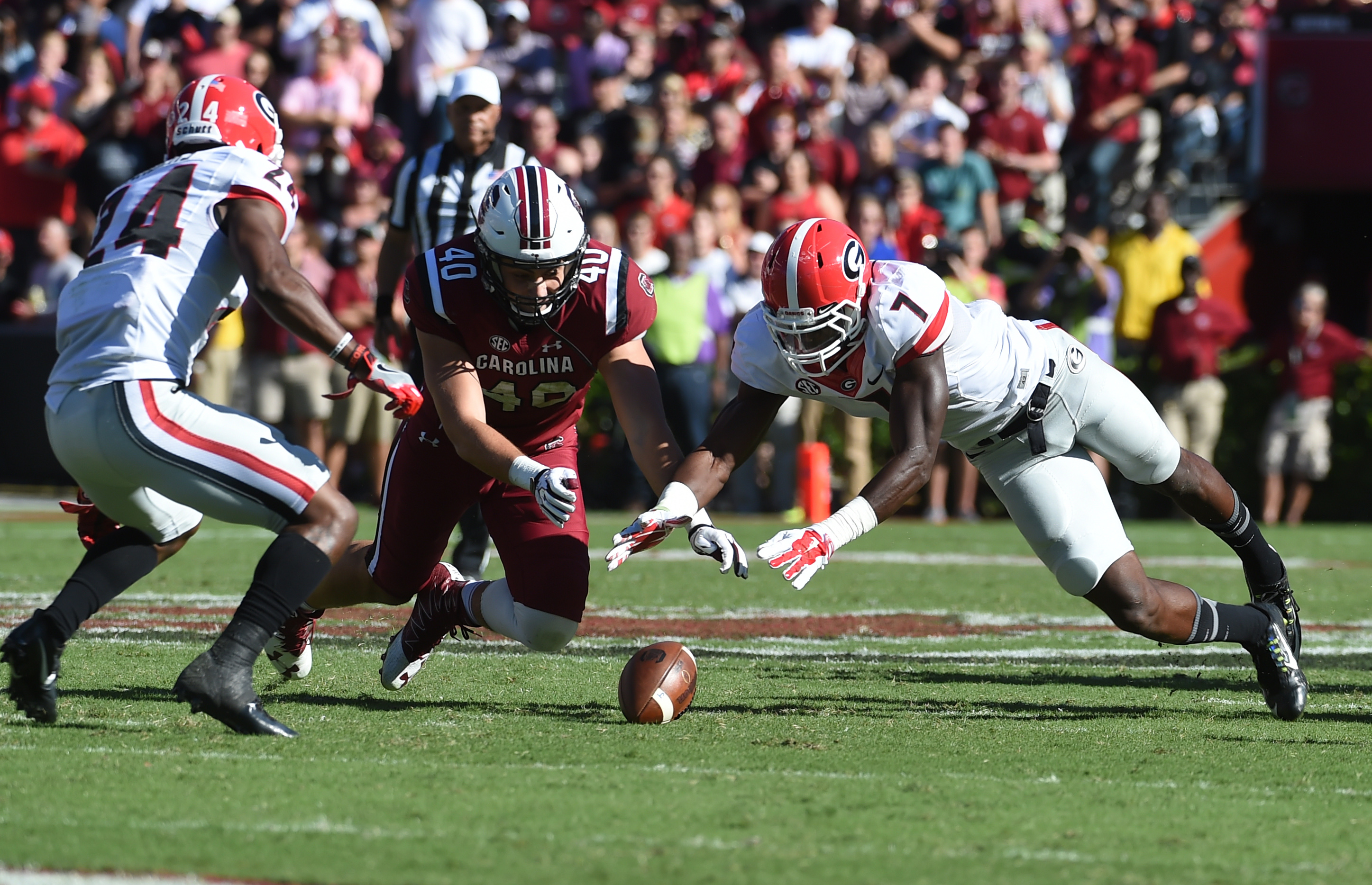 South Carolina tight end Jacob August (40) and Georgia linebacker Lorenzo Carter (7) reach for a fumble during the first half of an NCAA college football game on Sunday, Oct. 9, 2016, in Columbia, S.C. Georgia recovered the fumble on the play. (AP Photo/Rainier Ehrhardt)