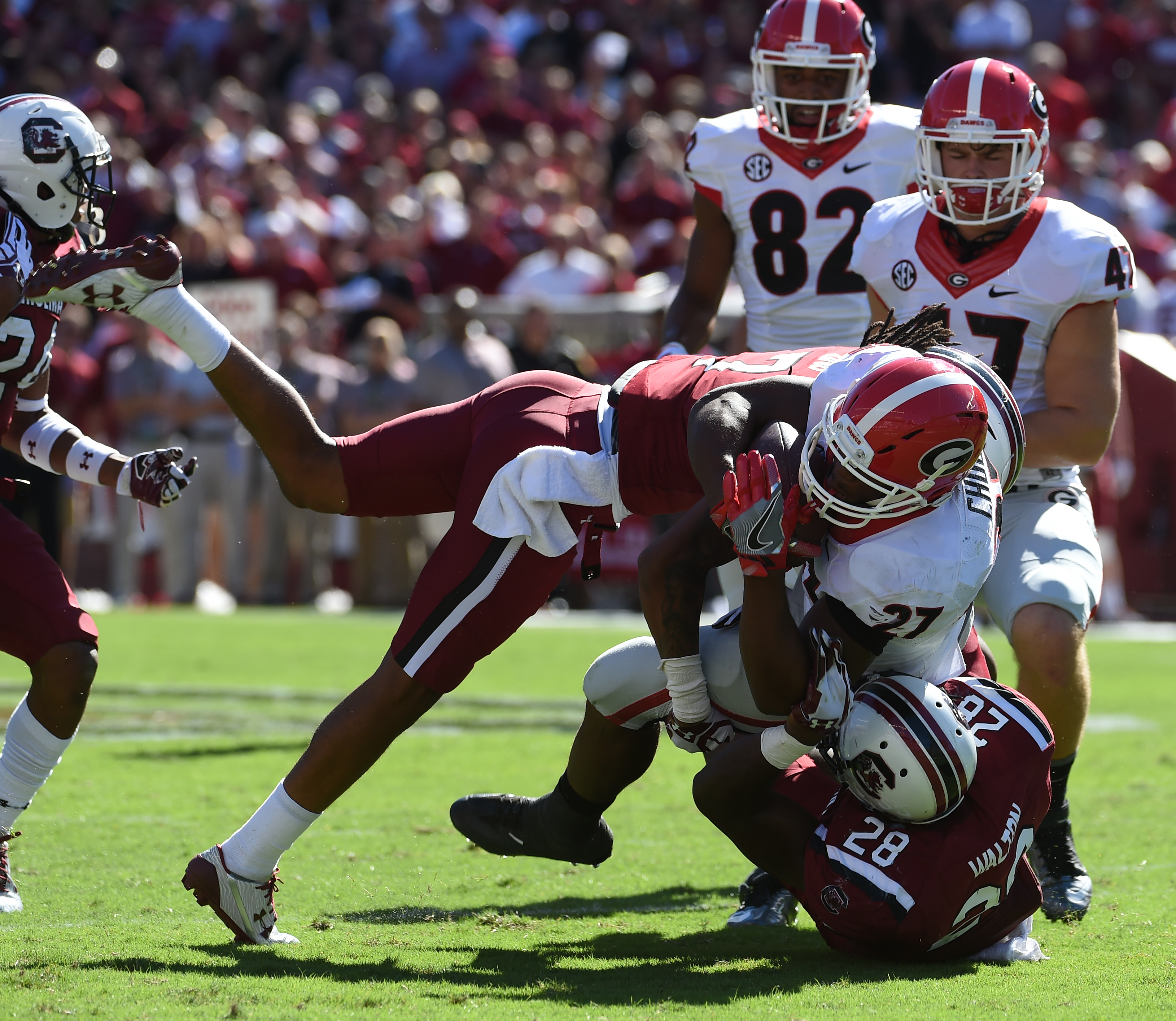 Georgia running back Nick Chubb (27) is tackled by South Carolina defensive back Jamarcus King (7) and teammate Jonathan Walton (28) during the first half of an NCAA college football game on Sunday, Oct. 9, 2016, in Columbia, S.C. (AP Photo/Rainier Ehrhardt)