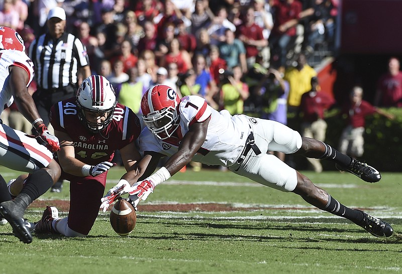 South Carolina tight end Jacob August (40) and Georgia linebacker Lorenzo Carter (7) reach for a fumble during the first half of an NCAA college football game on Sunday, Oct. 9, 2016, in Columbia, S.C. Georgia recovered the fumble on the play. (AP Photo/Rainier Ehrhardt)