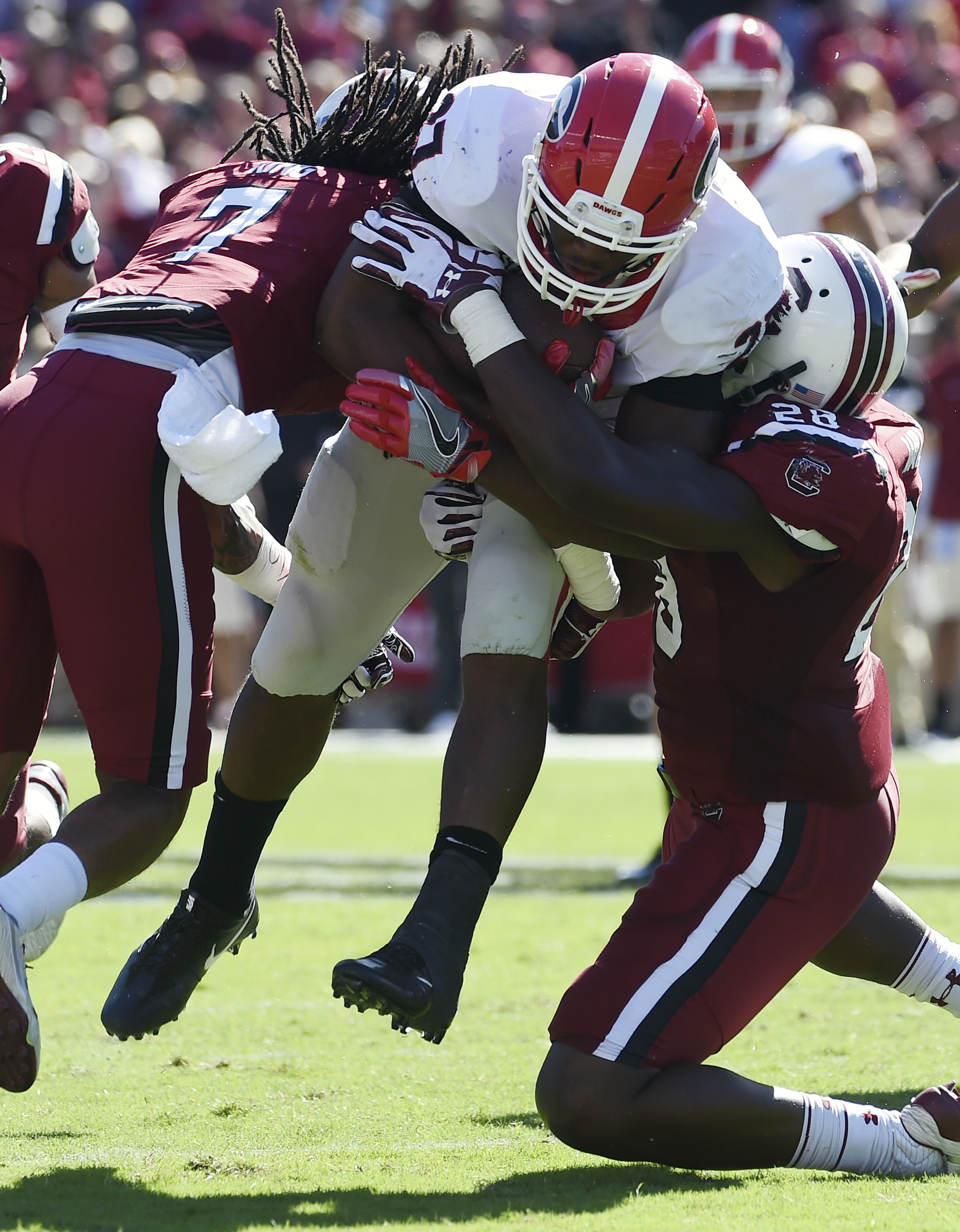 Georgia running back Nick Chubb (27) is tackled by South Carolina defensive back Jamarcus King (7) and Jonathan Walton (28) during the first half of an NCAA college football game on Sunday, Oct. 9, 2016, in Columbia, S.C. (AP Photo/Rainier Ehrhardt)
