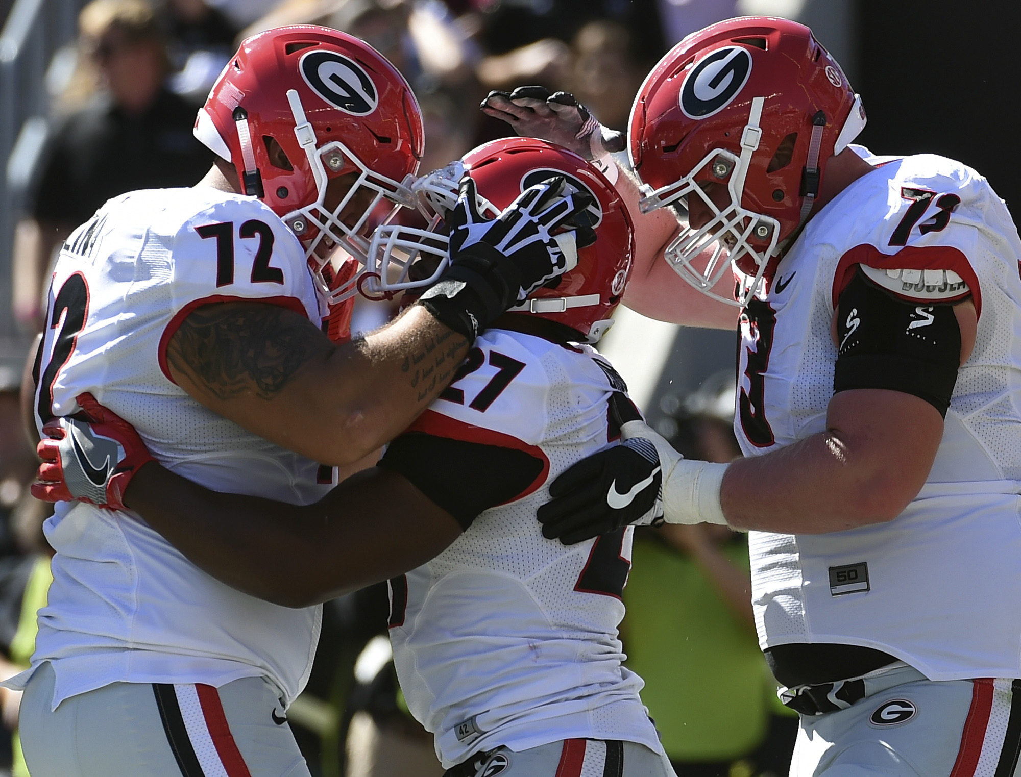 Georgia running back Nick Chubb (27) celebrates a touchdown with teammates Tyler Catalina (72) and Greg Pyke (73) during the first half of an NCAA college football game against South Carolina on Sunday, Oct. 9, 2016, in Columbia, S.C. (AP Photo/Rainier Ehrhardt)