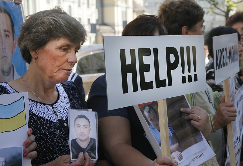 
              FILE - In this photo taken Wednesday, Sept. 14, 2016, relatives of Ukrainian prisoners of war hold their portraits at a rally outside the German embassy in Kiev, Ukraine. Under the last Feb. Russia-Ukraine-France-Germany agreement on ending the war between Russia-backed separatists and Ukrainian forces, the sides agreed on an “all-for-all” prisoner exchange. Although the numbers held by each side are in dispute, it’s clear that the pace of release has slowed markedly for Ukrainians held by the rebels. Since the peace agreement was signed, 83 Ukrainian prisoners have been released, but only 12 of them were freed this year. (AP Photo/Efrem Lukatsky)
            