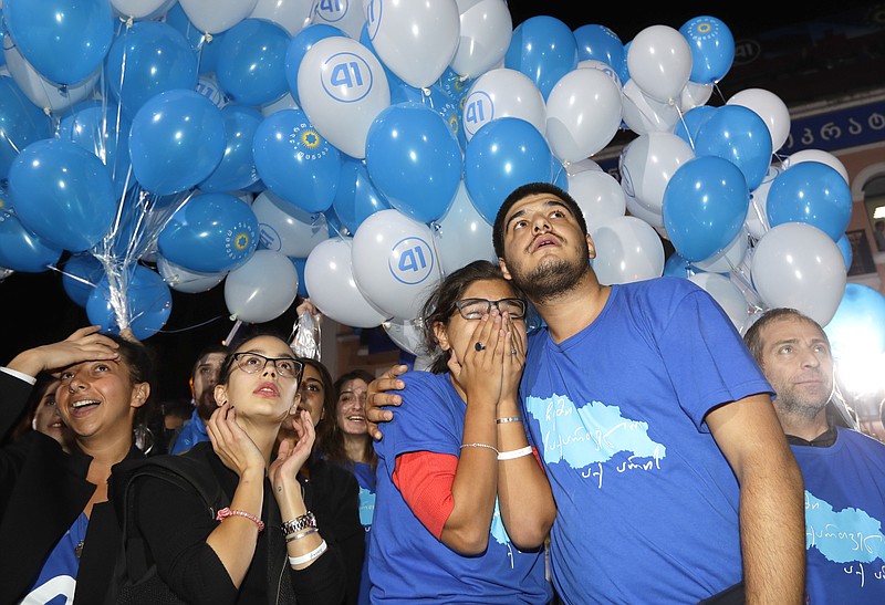 
              Supporters of ruling Georgian Dream party take part in a rally in Tbilisi, Georgia, Saturday, Oct. 8, 2016. Two exit polls in Georgia's parliamentary election show the ruling party in the lead, but the polls differ sizably on the margin of victory. (AP Photo/Sergei Grits)
            