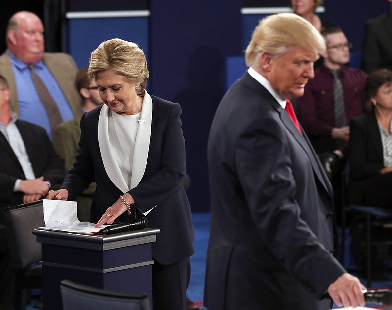 Democratic presidential nominee Hillary Clinton and Republican presidential nominee Donald Trump go to their tables in the second presidential debate at Washington University in St. Louis, Sunday. (Rick T. Wilking/Pool via AP)