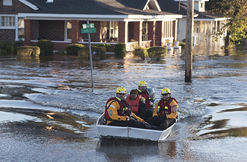 
              A swift water rescue team transports a resident of to safety on a street covered with floodwaters caused by rain from Hurricane Matthew in Lumberton, N.C., Monday, Oct. 10, 2016. (AP Photo/Mike Spencer)
            