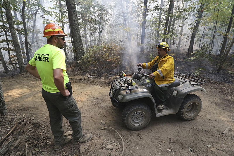 Staff Photo by Dan Henry / The Chattanooga Times Free Press- 10/12/16. Anthony Jones, a ranger with The Cumberland Trail speaks to Brian Haddock with the Tennessee Division of Forestry while maintaining a fire line and continue to battle a wildfire burning atop Signal Mountain.