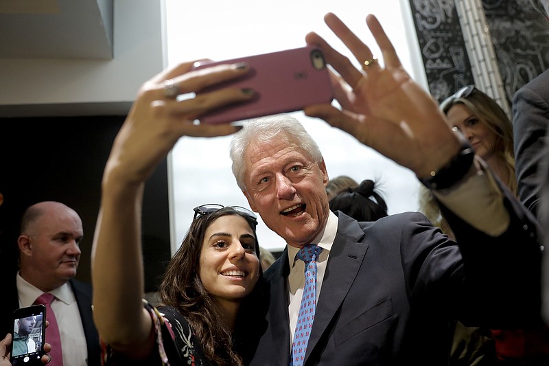 
              FILE - In this Sept. 13, 2016, file photo, former President Bill Clinton pauses for a selfie with a supporter at a coffee shop while campaigning for his wife, Democratic presidential candidate Hillary Clinton in Los Angeles. Ignoring his own sexually aggressive predilections, Donald Trump wants voters to see Bill Clinton as a scandal-plagued cad whose history with women should disqualify Hillary Clinton from the presidency. The argument doesn’t seem to resonate with America’s youngest voters, who know the 70-year-old former president as a figure out of history books and don’t seem to care about his Oval Office affair with Monica Lewinsky or other marital infidelities.  (AP Photo/Jae C. Hong, File)
            