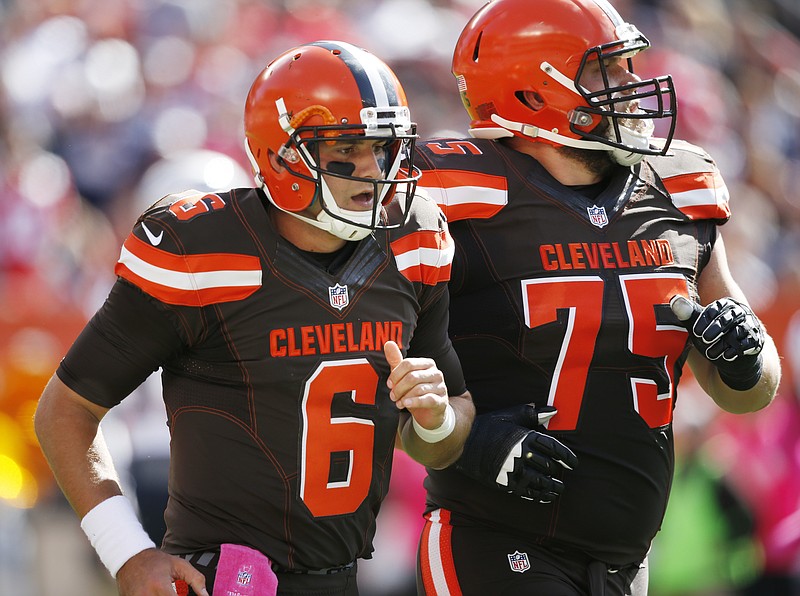 In this Oct. 9, 2016, file photo, Cleveland Browns quarterback Cody Kessler (6) walks off the field with Joel Bitonio after being injured on a hit by New England Patriots outside linebacker Dont'a Hightower in the first half of an NFL football game, in Cleveland. The Browns (0-5) and Titans (2-3) play Sunday, Oct. 16, 2016.(AP Photo/Ron Schwane, File)