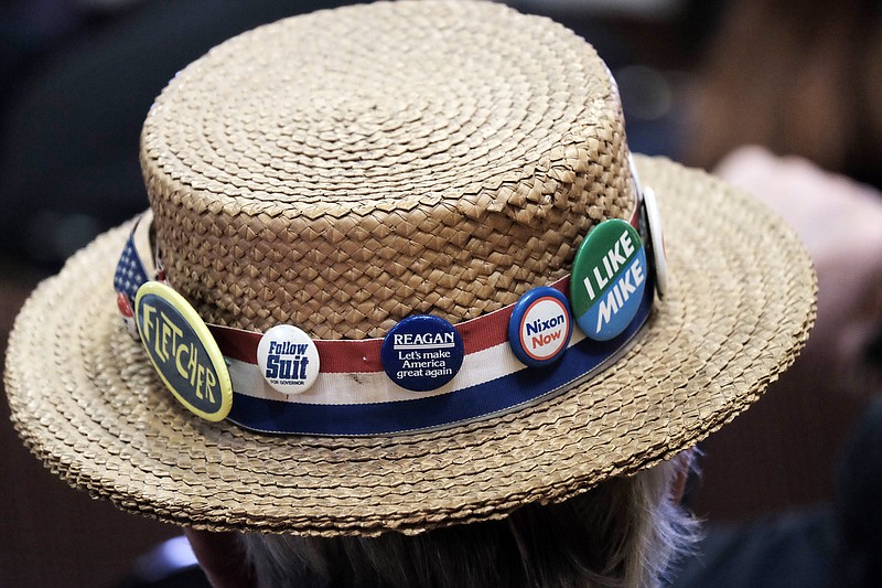 A delegate at the Georgia Republican State Convention in June wears a hat with lots of campaign pins, including two for former Republican Presidents Richard Nixon and Ronald Reagan.