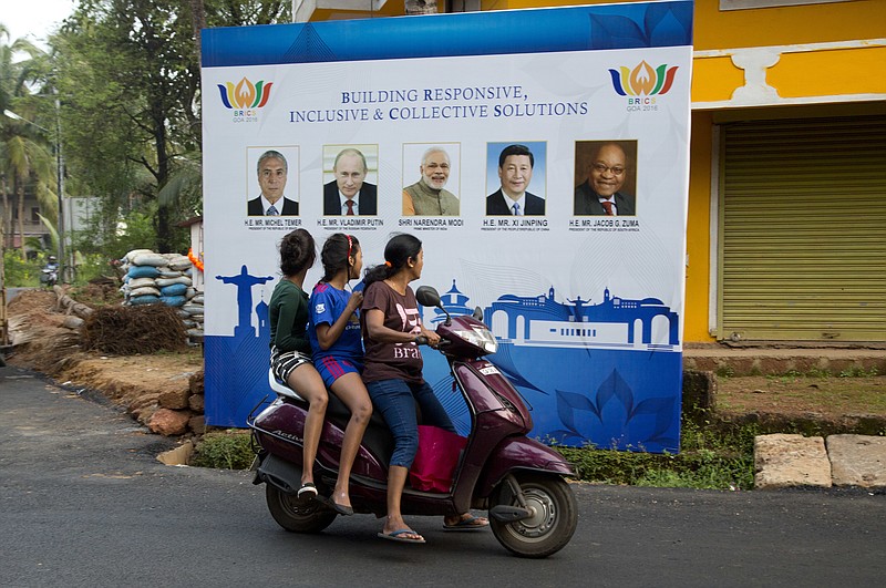 
              Indian girls on a scooter watch the poster of BRICS with the photographs of their leaders, in Goa, Thursday, Oct. 13, 2016. India will host the 8th Brazil, Russia, India, China and South Africa or BRICS Summit during its Chairmanship, which is scheduled to take place on 15-16 October 2016 in Indian western state of Goa. (AP Photo/Anupam Nath)
            