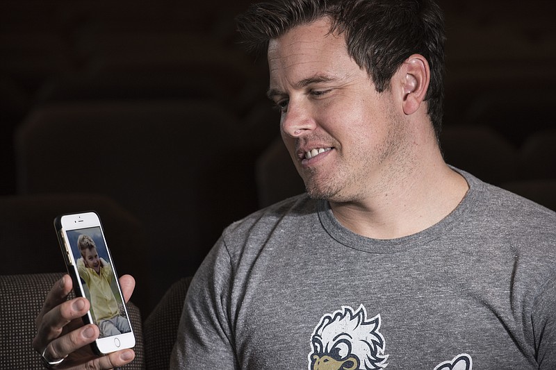 Brent Moxey, the youth pastor at West Ridge Church in Dallas, Ga., poses for a photo on Aug. 18, 2016, holding his phone showing a photo of Holston Cole, a 3-year-old parishioner who died in April after accidentally shooting himself with his father's handgun. "For him, I think he just loved to discover things and figure out how stuff worked, and look at stuff and tinker," Moxey says. (AP Photo/Lisa Marie Pane)