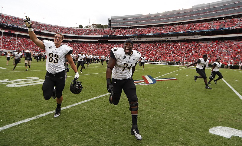 Vanderbilt defensive lineman Jay Woods (74) and Vanderbilt tight end Nathan Marcus (83) runs off the field after defeating Georgia 17-16 in the second half of an NCAA college football game Saturday, Oct. 15, 2016, in Athens, Ga. (AP Photo/John Bazemore)


