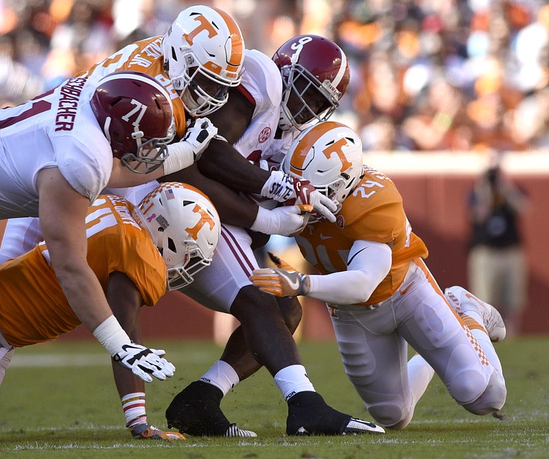 Tennessee defenders gang-tackle Alabama tailback Bo Scarbrough during Saturday's game at Neyland Stadium. The Crimson Tide rushed for 438 yards in their 49-10 win.