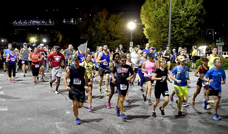 Runners emerge from the darkness as the 7 Bridges Marathon gets under way before dawn Sunday.  The 7 Bridges Marathon and 4 Bridges Half Marathon, along with a 5K run were held simultaneously Sunday October 16, 2016 along the Tennessee River in Chattanooga.