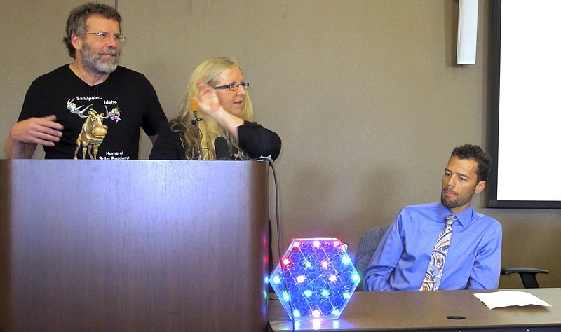 
              In this Sept. 30, 2016, photo, Solar Roadways founders Scott Brusaw, left, and Julie Brusaw display a one-third sized replica of one of their solar pavement panels at a news conference in Sandpoint, Idaho as Sandpoint mayor Shelby Rognstad looks on at right. Rognstad said the company is drawing visitors to the resort town. Solar Roadways recently unveiled its first public installation in a downtown plaza in the resort town of Sandpoint: about 150 square feet of hexagon-shaped solar panels that people can walk and bicycle on. (AP Photo/Nicholas K. Geranios)
            
