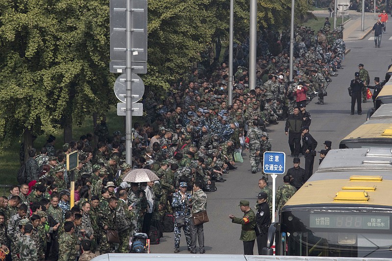 
              FILE - In this Tuesday, Oct. 11, 2016, file photo, hundreds of protesters in green fatigues gather outside the Chinese Ministry of National Defense to protest in Beijing. Fed up with paltry pensions and benefits, China's veterans are increasingly taking to the streets, hoping to shame the government into recognizing its obligation to those who battled along the country's borders, often in extremely harsh conditions. (AP Photo/Ng Han Guan, File)
            