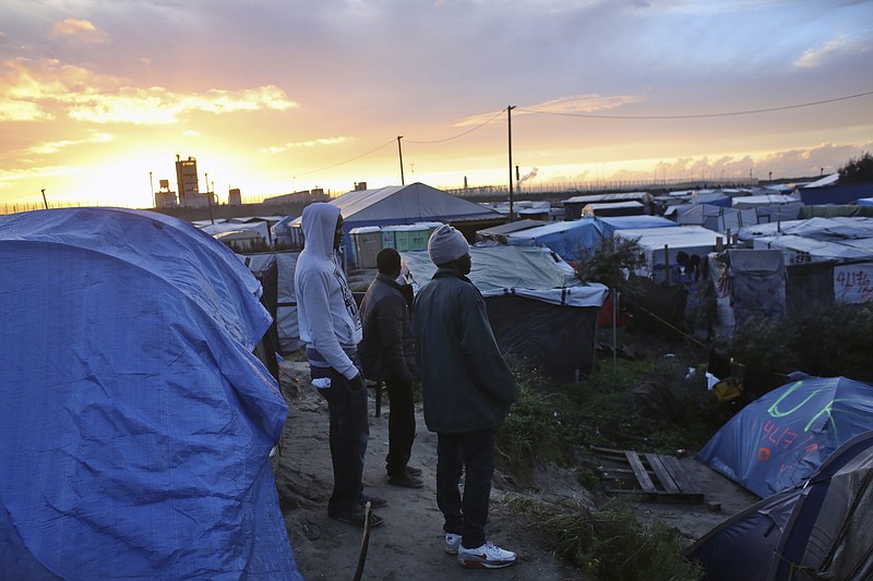 
              Migrants stand in a makeshift migrants camp near Calais, France, Sunday, Oct. 16, 2016. The government is gradually deporting migrants without right to asylum and relocating the rest to more than 160 centers around France. It is expected to close the camp in the coming weeks but no official dates have been announced. (AP Photo/Thibault Camus)
            