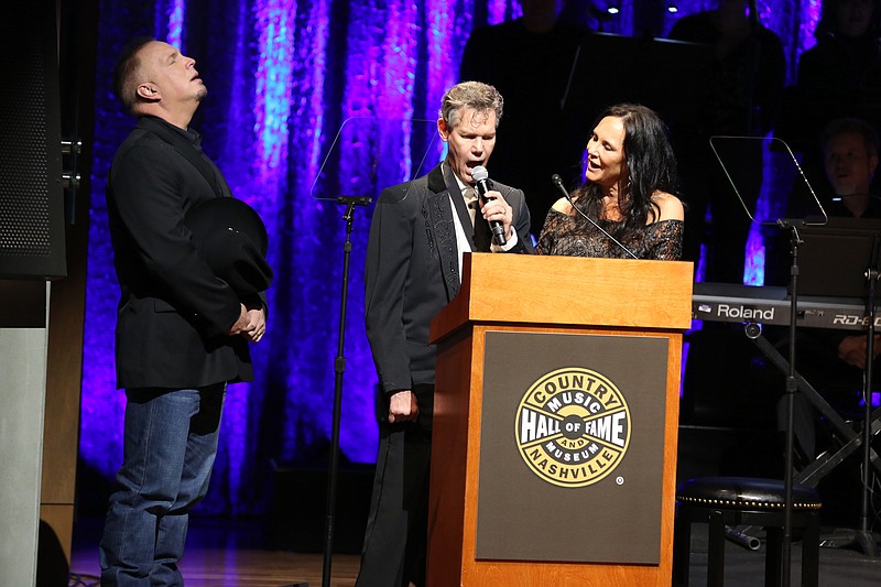 
              From left, artist Garth Brooks, artist Randy Travis and Mary Travis sing "Amazing Grace" at the Country Music Hall of Fame Medallion Ceremony at the Country Music Hall of Fame and Museum on Sunday, Oct. 16, 2016 in Nashville, Tenn. (Photo by Laura Roberts/Invision/AP)
            