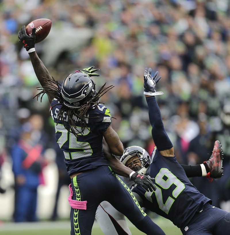 Seattle Seahawks cornerback Richard Sherman (25) and Earl Thomas (29) break up a pass intended for Atlanta Falcons wide receiver Julio Jones (obscured) in the second half of an NFL football game, Sunday, Oct. 16, 2016, in Seattle. The Seahawks defeated the Falcons 26-24. (AP Photo/Stephen Brashear)