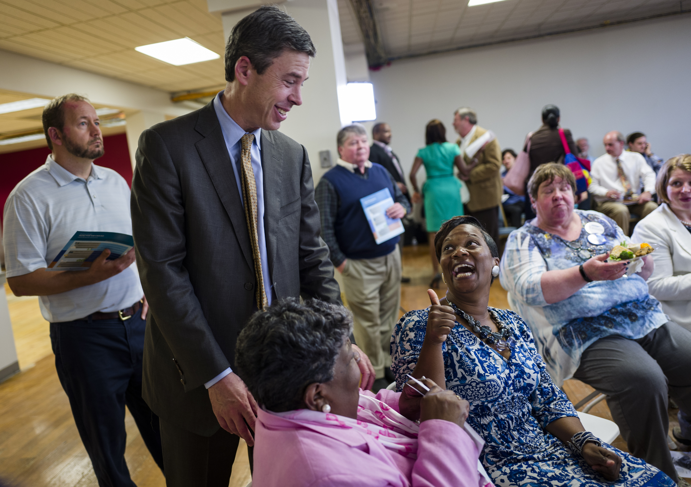 Mayor Andy Berke, left, greets Samevelyn Rock, left, and LeAndrea Ware before a forum hosted by the Times Free Press titled
