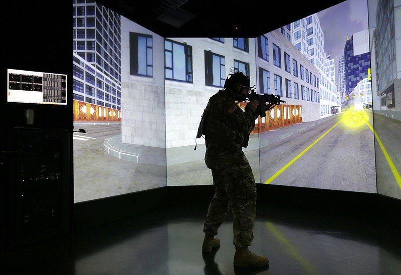 
              A soldier stands in a virtual reality lab wearing a headset to measure his cognitive responses under stress, Tuesday, Oct. 18, 2016, at the Center for Applied Brain and Cognitive Sciences in Medford, Mass. The Center was jointly founded by the Army's Natick Soldier Research, Development and Engineering Center and Tufts University's School of Engineering. (AP Photo/Elise Amendola)
            