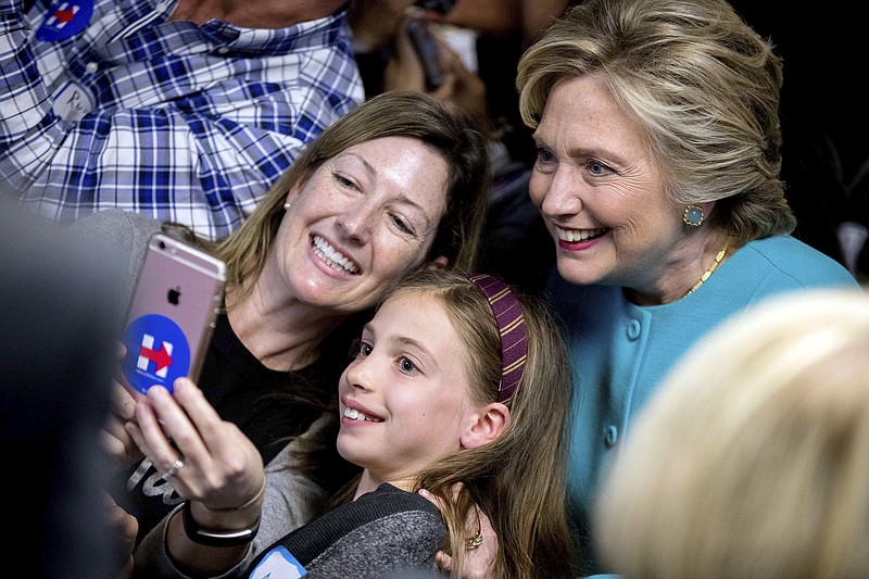 Democratic presidential candidate Hillary Clinton takes a photograph with supporters at a campaign office in Seattle, Friday, Oct. 14, 2016. 