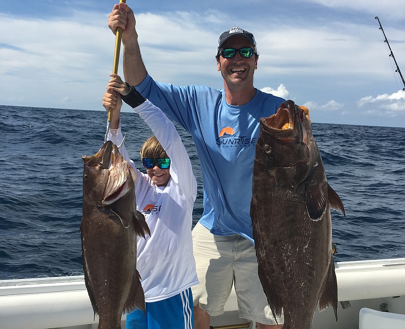 Teddy Wingfield gets some help from his father, Joseph, in holding up Teddy's 32-pound world-record scamp and another big one he caught off the coast of North Carolina in June.