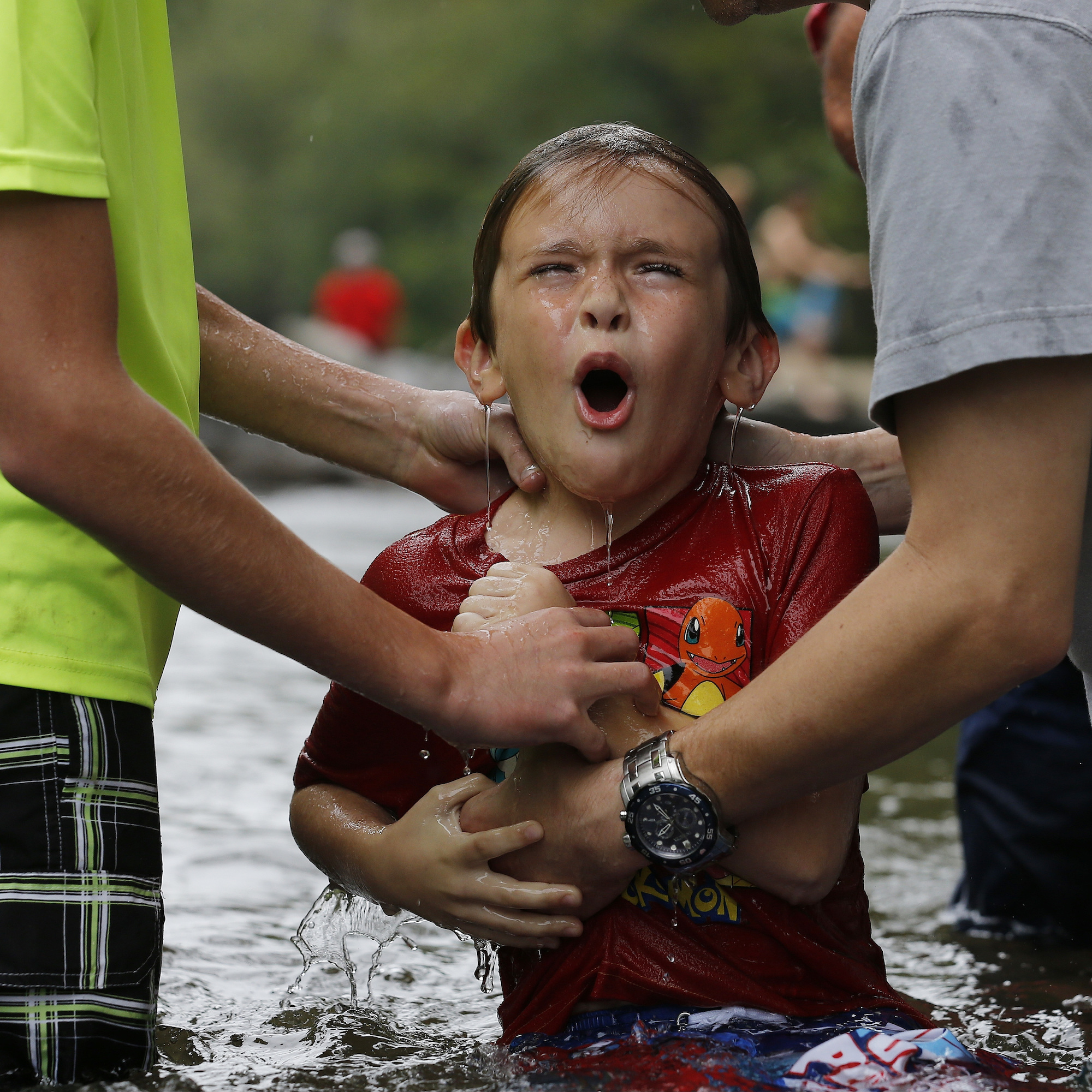 Nicholas Lewis reacts as he is baptized.