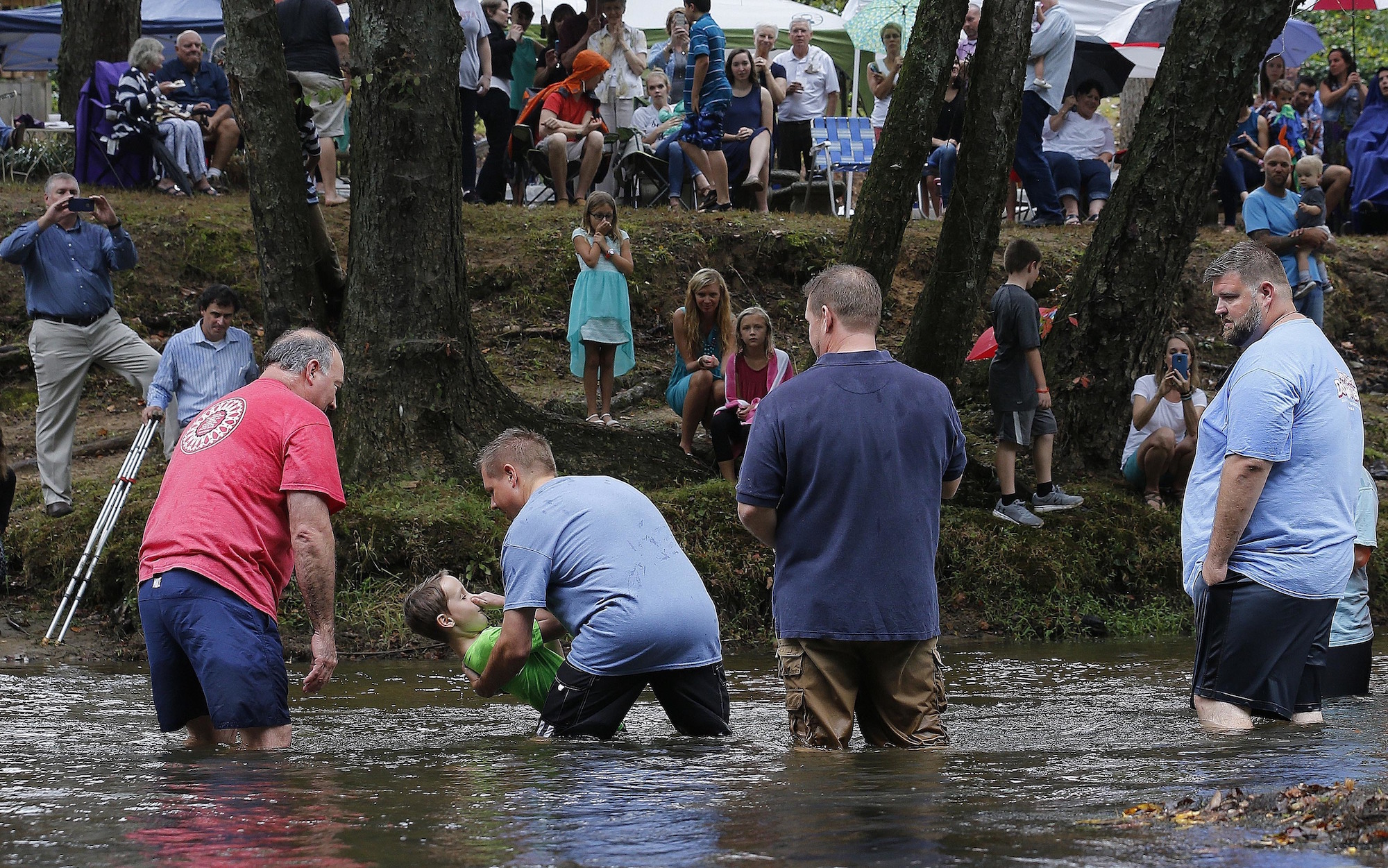 Jamie Spinks baptizes his son, Grayson, 8, in the in the Chattahoochee River.