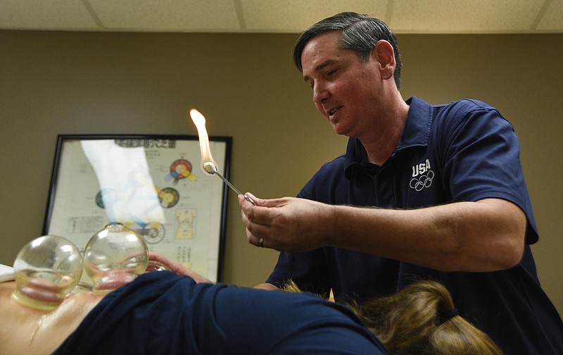 Bret Moldenhauer applies a cup to Jesslynn Stockard, a University of Tennessee at Chattanooga softball player who had vertebrae compression in her lower back that caused nerve pain in both legs.