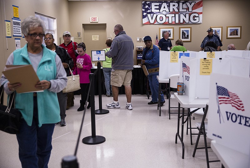 Voters wait in line to place their paper ballots into a voting machine during early voting at the Hamilton County Election Commission on Amnicola Highway on Saturday, Oct. 22, 2016, in Chattanooga, Tenn.