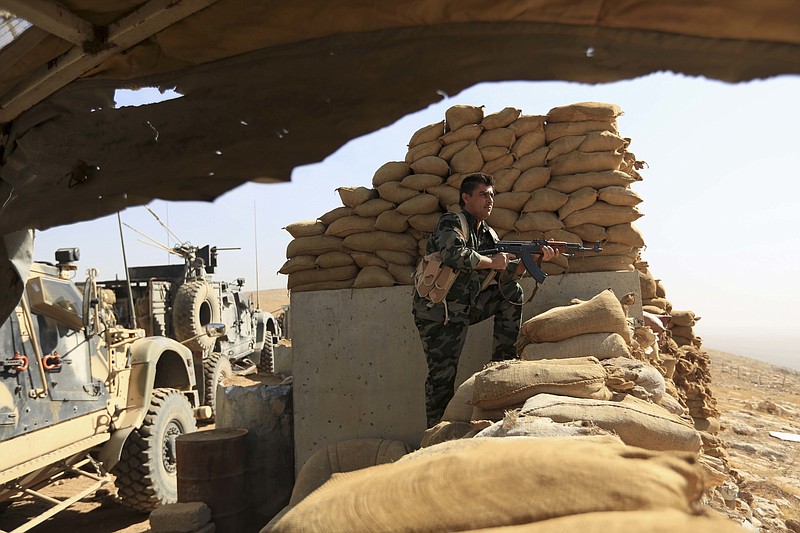 
              An Iraqi Kurdish Peshmerga fighter stands guard outside Bartella, Iraq, Friday, Oct. 21, 2016. By Thursday, the Iraqi forces had advanced as far as Bartella, a historically Christian town some nine miles (15 kilometers) from Mosul's outskirts. (AP Photo/ Khalid Mohammed)
            